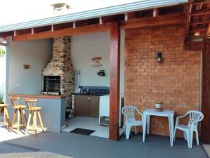 a patio with a table and chairs and a brick wall at Pousada e Hotel Italian Garden House in Campo Grande