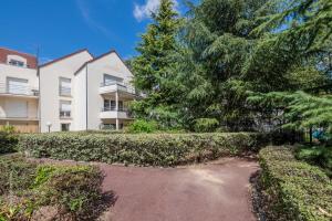 an apartment building with trees in front of it at Little Big Vacations - Fairytale Factory in Bussy-Saint-Georges