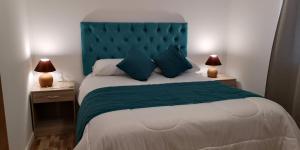 a bedroom with a large bed with a blue headboard at Cabañas Licanantay in Vallenar