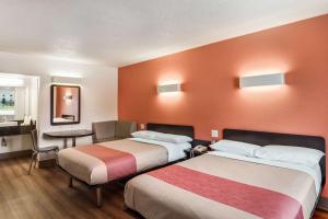 a hotel room with two beds and a table at Motel 6-Youngstown, OH in Youngstown