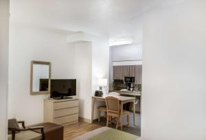 a living room with a kitchen and a table with a mirror at Studio 6-Fishers, IN - Indianapolis in Fishers