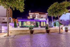 a house with purple lights on it at night at Villa Mariazinha Charming Hotel in Portimão