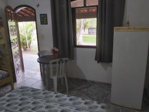 um quarto com uma mesa, uma cadeira e uma janela em Pousada Jorai e Camping em Bertioga