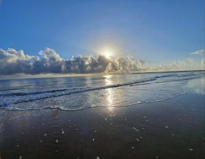 una playa con el sol brillando en el agua en ABSOLUTE BEACH FRONT MACKAY - Blue Pacific, en Mackay