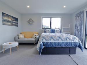 a bedroom with a bed and a couch at The Tui Studio - Te Anau Holiday Studio in Te Anau