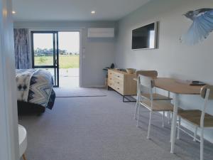 a bedroom with a table and a bed and a desk at The Tui Studio - Te Anau Holiday Studio in Te Anau