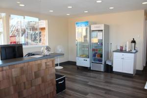 a large kitchen with a refrigerator and a counter at Inn at the Sea in Long Beach