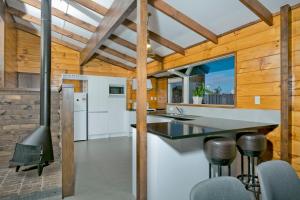 uma cozinha com paredes de madeira e um grande balcão com bancos em Poenamo Hotel em Auckland