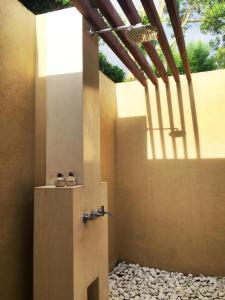La salle de bains est pourvue d'une douche avec deux chaussures sur la porte. dans l'établissement Villa Vanna - Lombok, à Senggigi