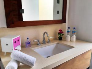 a bathroom sink with a soap dispenser and a mirror at Villa Vanna - Lombok in Senggigi 