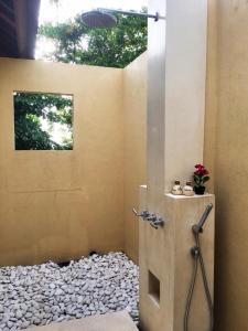 een badkamer met een douche en een berg rotsen bij Villa Vanna - Lombok in Senggigi 