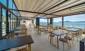 um restaurante com mesas e cadeiras e vista para o oceano em Stubborn Hotel em Geoje