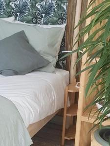 a bedroom with a bed and a potted plant at Boutique zomerhuis De groene Parel in Schoorl