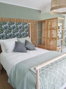 um quarto com uma grande cama branca com almofadas azuis em Boutique zomerhuis De groene Parel em Schoorl