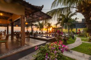 a restaurant with a view of the beach and palm trees at Amed Beach Resort in Amed