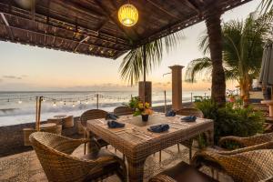 an outdoor dining area with a table and chairs and the ocean at Amed Beach Resort in Amed