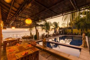 a resort with a swimming pool and a dining area at Amed Beach Resort in Amed