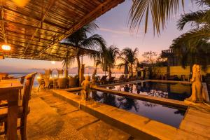 a resort with a swimming pool and palm trees at Amed Beach Resort in Amed