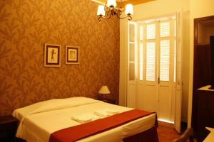 a bedroom with a bed and a window and a door at Avenida Charme Hotel in Águas de São Pedro