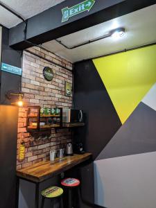 a bar with two stools and a yellow and black wall at Solar Di Petrópolis - Apartamentos de Temporada in Nova Petrópolis