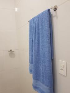a blue towel hanging on a towel rack in a bathroom at Estadia Confortável AP 102 in Juiz de Fora