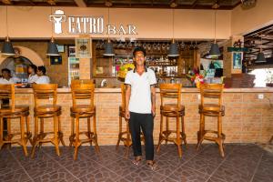 een man die voor een bar staat bij Amed Beach Resort in Amed