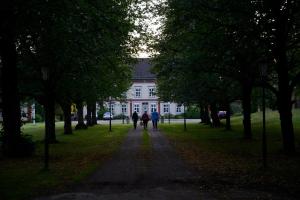 people walking down a path in front of a white house at Risberg Herrgård in Hagfors