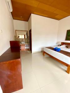 a bedroom with a bed and a mirror at Radya Homestay in Nusa Lembongan
