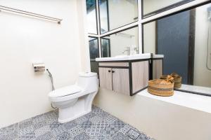 a bathroom with a toilet and a sink and a window at Tisha Langkawi Wellness Resort in Pantai Cenang +32 photos