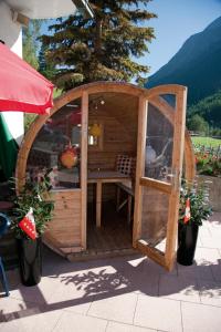 a wooden gazebo with a table in it at Pension Schönblick in Saas-Grund