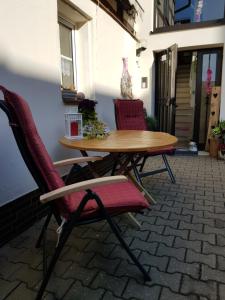 een houten tafel en 2 stoelen op een patio bij Ferienwohnung Itzgrundruhe in Untermerzbach