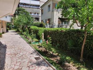 a garden with a walkway next to a hedge at Casa delle Conchiglie in Città Giardino