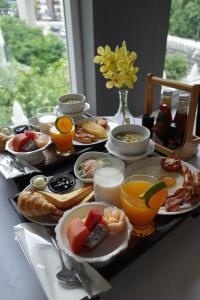 a table with breakfast foods and drinks on it at Hua Chang Heritage Hotel in Bangkok