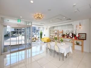comedor con mesa y sofá amarillo en Kumagaya Royal Hotel Suzuki en Kumagaya