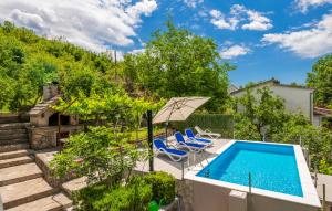 an outdoor swimming pool with chairs and an umbrella at Holiday Home Marijeta, Grab 2A, Trilj in Grab