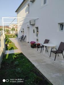 a patio with chairs and a table next to a white building at Old marine house in Tivat