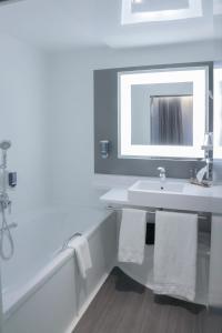 
a bathroom with a sink, toilet and tub at Novotel Suites Wien City in Vienna
