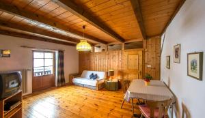 a living room with a table and a couch and a television at Krüglwirt in San Lorenzo di Sebato