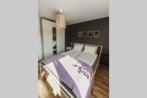 um quarto com uma cama com um edredão roxo e branco em Piastowska sleeping - mieszkanie w centrum miasta em Krosno