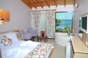 a bedroom with a bed and a tub and a window at Hotel Mola in Marmara Adasi