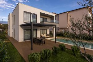 a house with a table and a swimming pool at Villa Lu-Ma Beachfront with Heated Pool in Turanj +39 photos