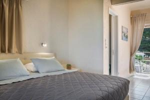 um quarto com uma cama grande e uma janela em Panorama Fanari studios and apartments em Argostoli