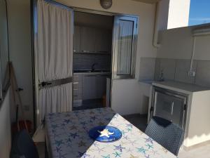 una piccola cucina con tavolo e piatto di Appartamenti in paese a poca distanza dal mare a Lampedusa