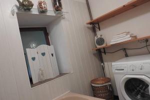 ein Badezimmer mit einer Waschmaschine und einem Spiegel in der Unterkunft Cazabonne in Salles