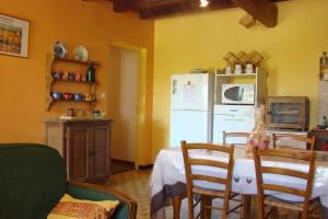 una cucina con tavolo, sedie e frigorifero bianco di Cazabonne a Salles