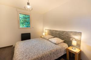 a bedroom with a bed and a window at le chalet in Airaines