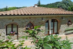 uma casa de pedra com três janelas e um telhado em Il Fienile em Ripafratta