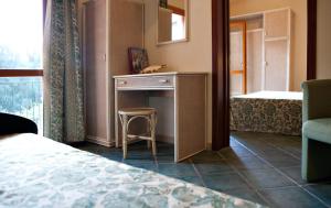 a bedroom with a table and a stool in a room at Hotel Danila in Portoferraio
