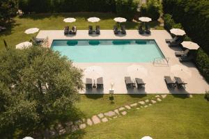 an overhead view of a swimming pool with chairs and umbrellas at Hotel Pollinger in Merano
