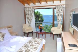 a bedroom with a bed and a view of the ocean at Mola Hotel in Marmara Adasi